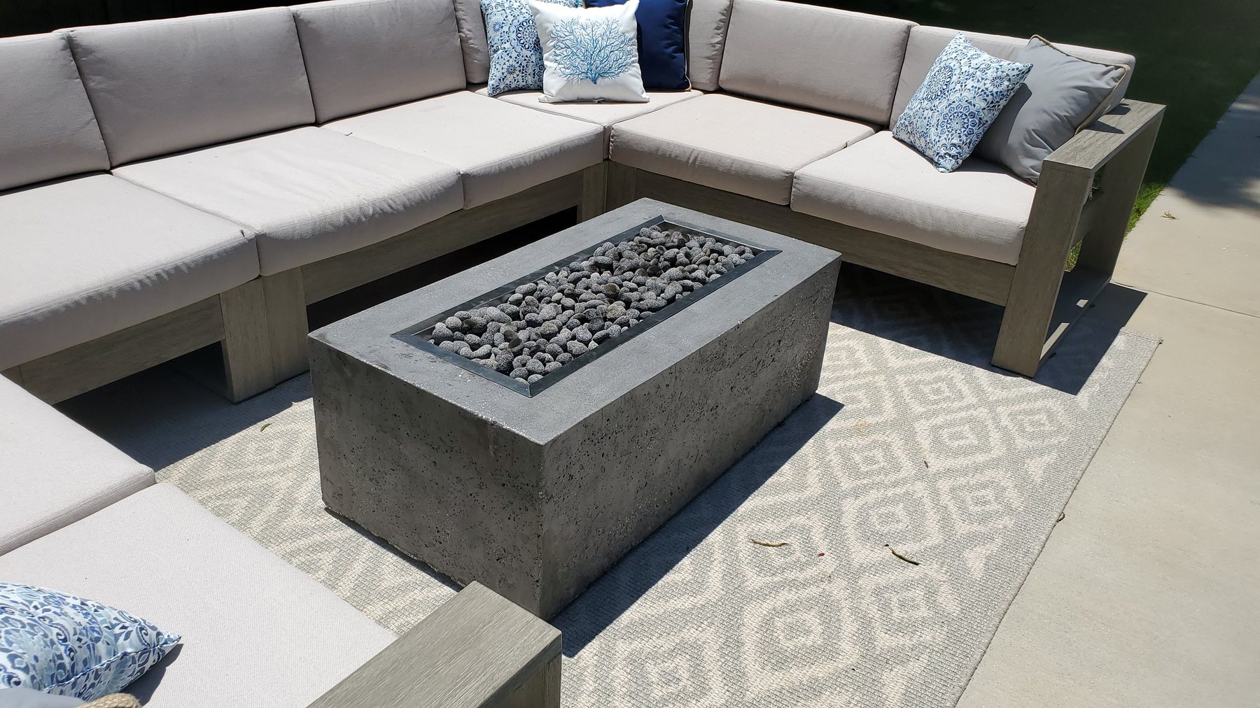 Finished rectangular custom gas fire table in an outdoor seating area
