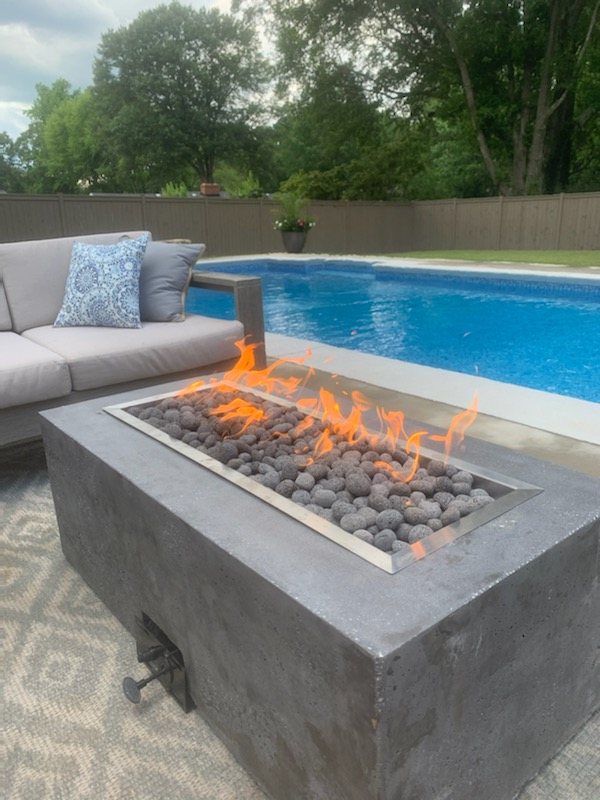 Custom rectangular gas fire table burning beside a swimming pool