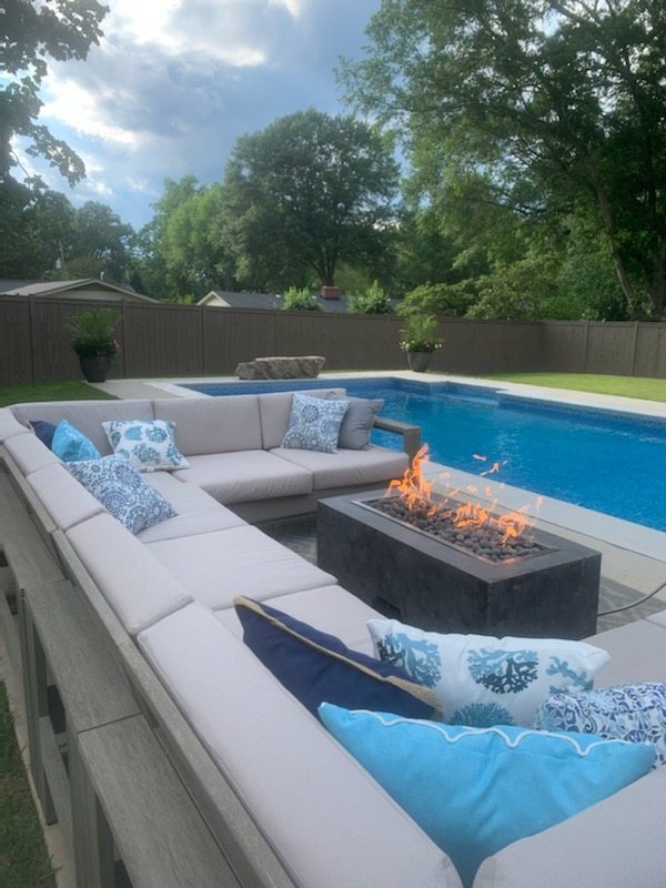 Custom gas fire table built by Eleven17 beside a pool
